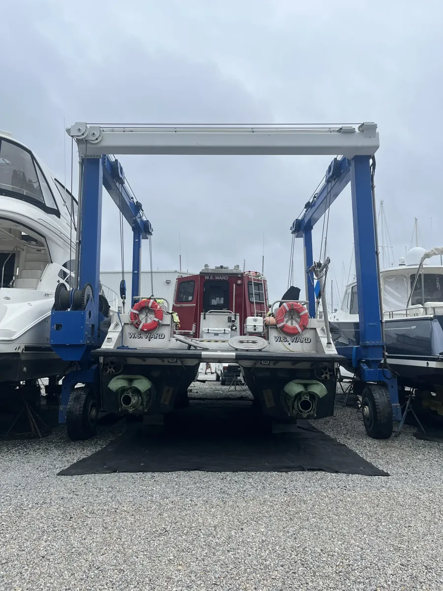 A workboat slung in the travel lift at the yard